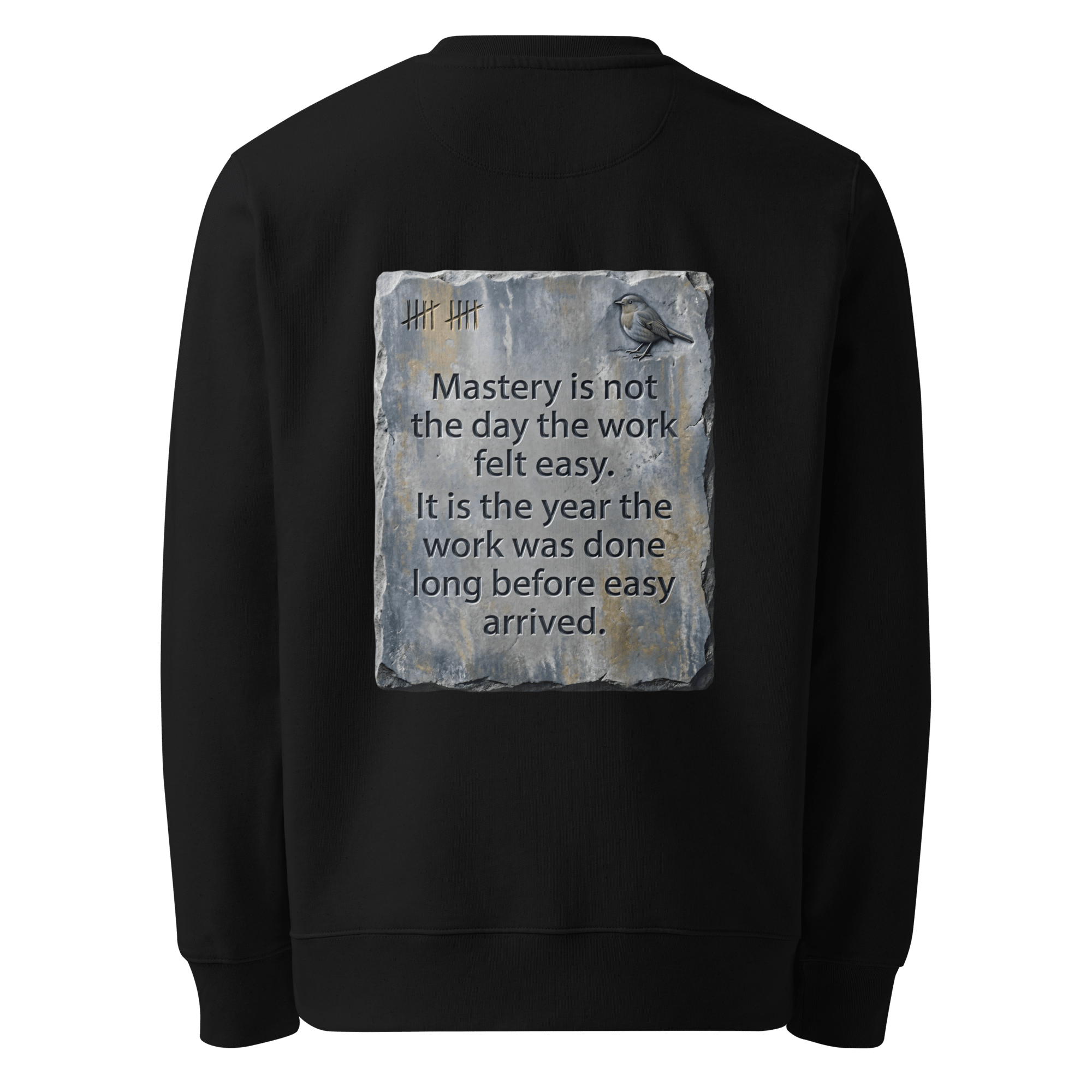 Long Before Easy sweater, black — back view of worn metal slogan plate with robin, reading "Mastery is not the day the work felt easy. It is the year the work was done long before easy arrived." — Ricki Robin