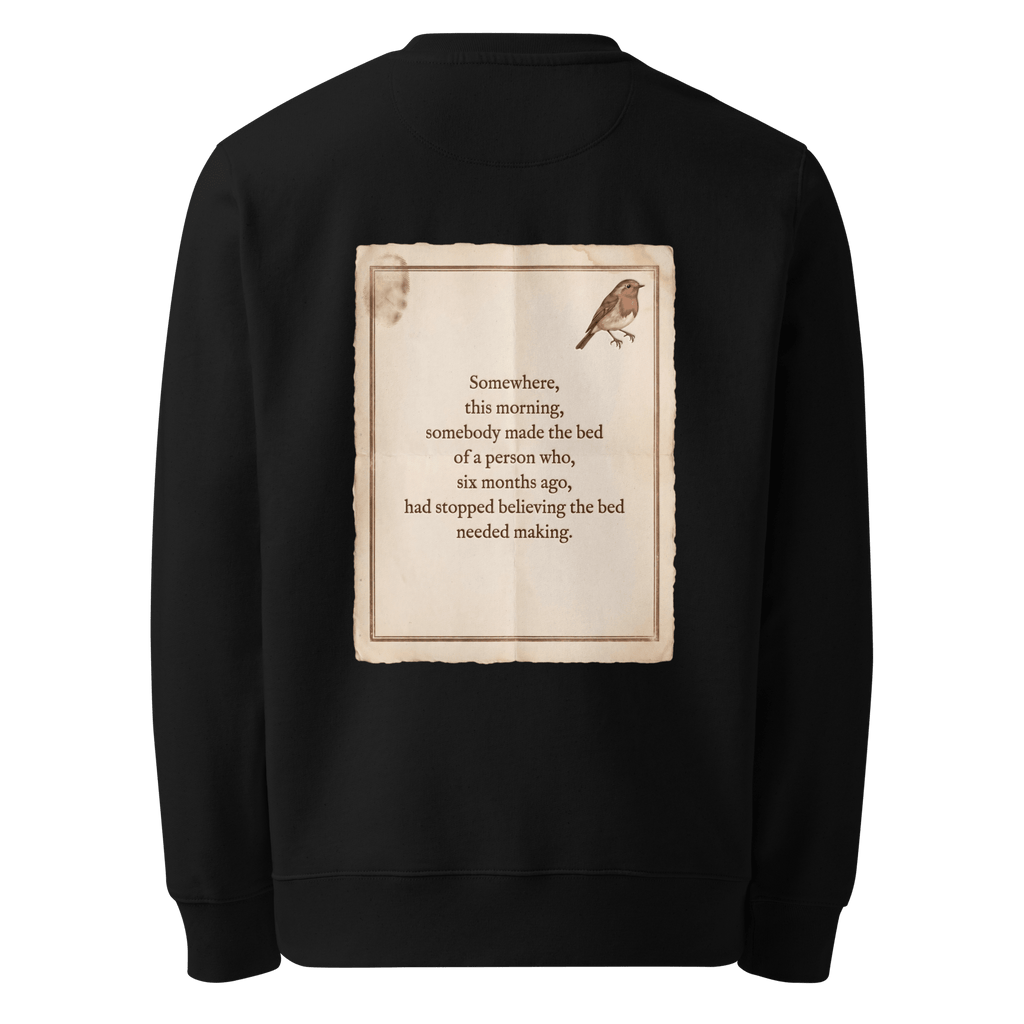 Made The Bed sweater, black — back view of aged paper slogan plate with robin, reading "Somewhere, this morning, somebody made the bed of a person who, six months ago, had stopped believing the bed needed making." — Ricki Robin
