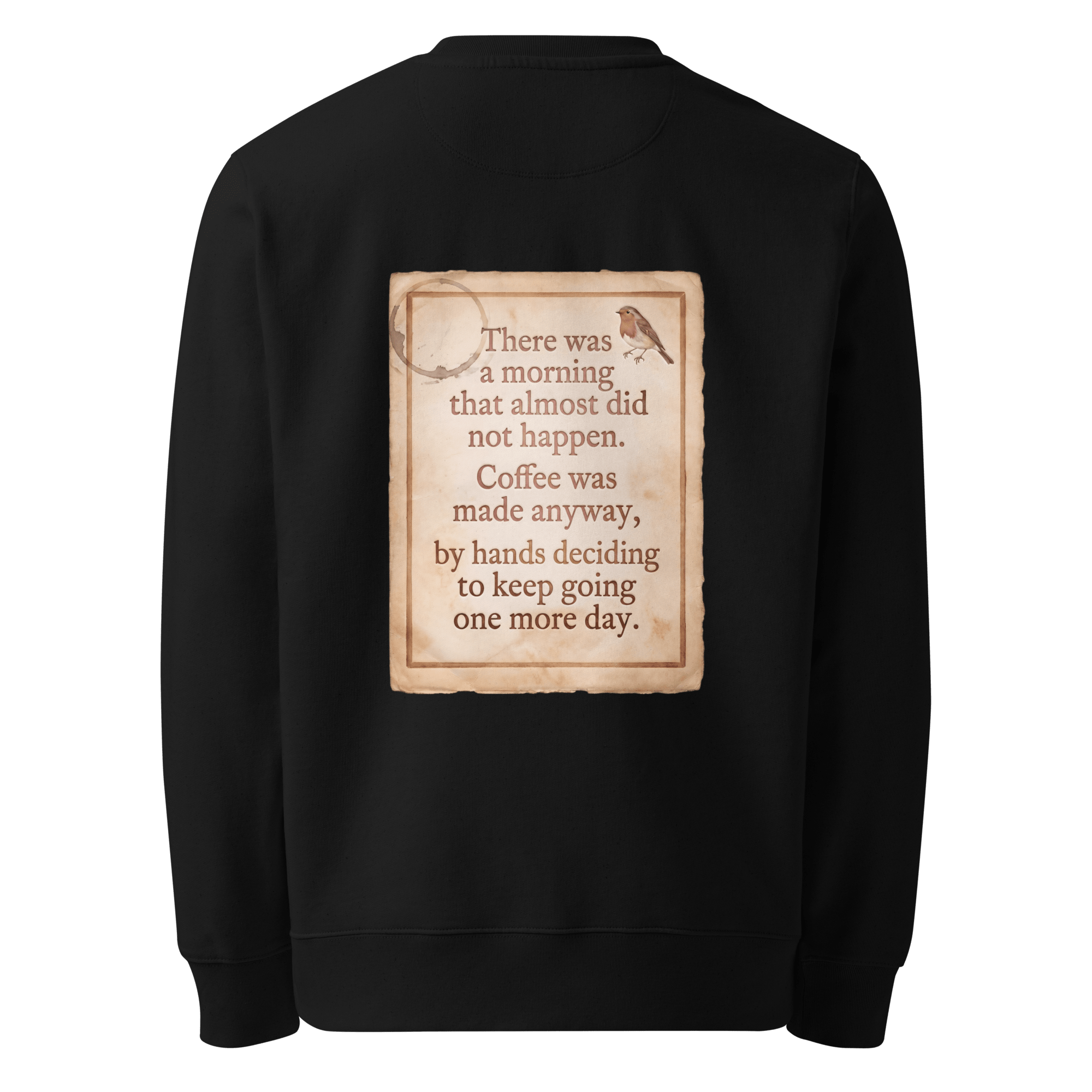 Made Anyway sweater, black — back view of coffee-stained paper slogan plate with robin, reading "There was a morning that almost did not happen. Coffee was made anyway, by hands deciding to keep going one more day." — Ricki Robin