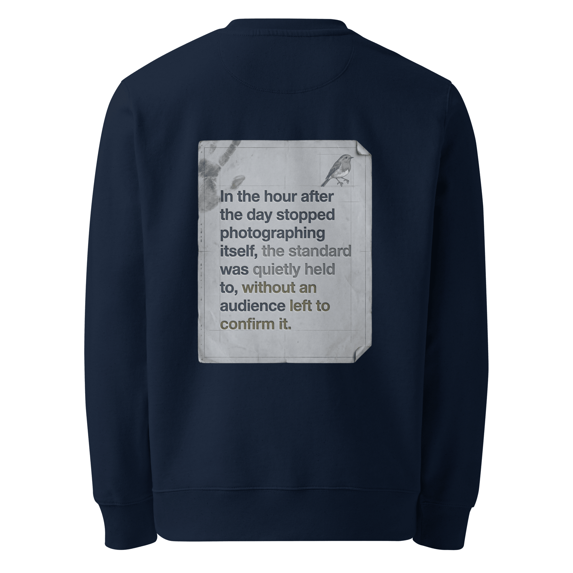 Quietly Held sweater, French Navy — back view of torn paper slogan plate with robin, reading "In the hour after the day stopped photographing itself, the standard was quietly held to, without an audience left to confirm it." — Ricki Robin