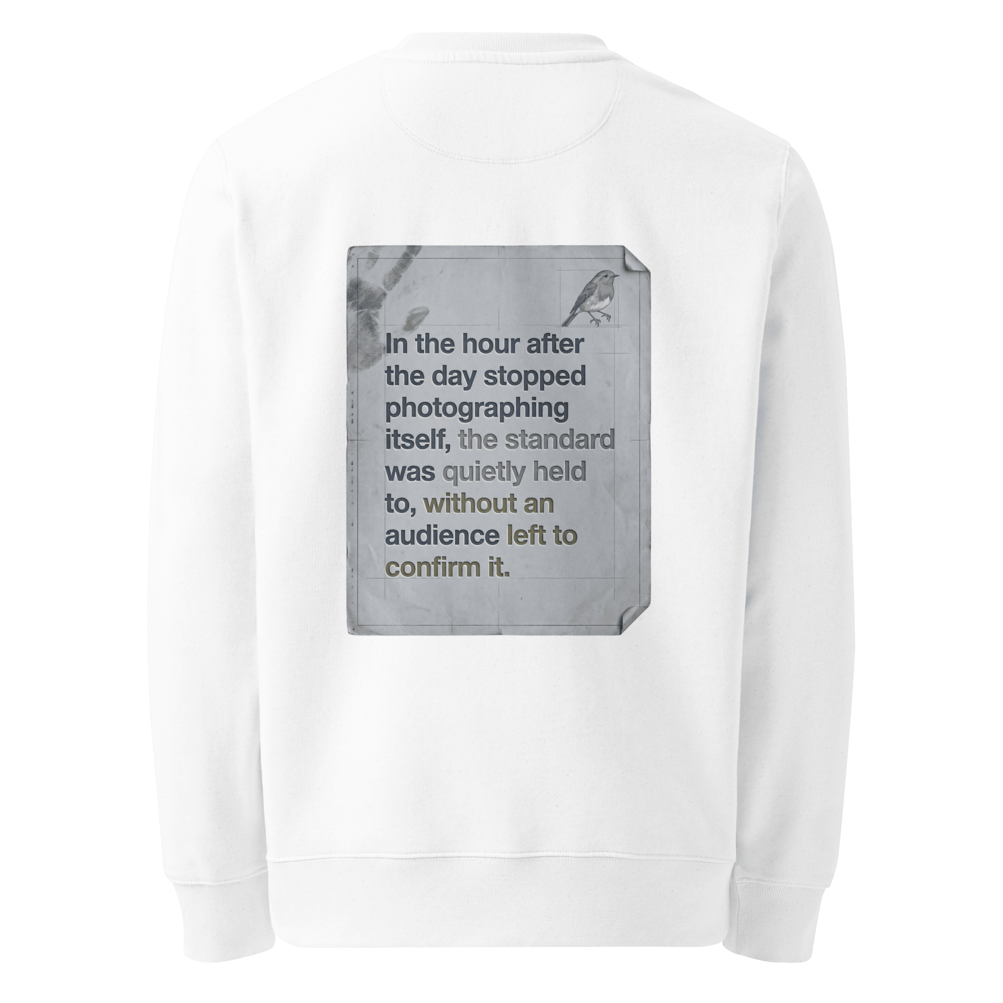 Quietly Held sweater, white — back view of torn paper slogan plate with robin, reading "In the hour after the day stopped photographing itself, the standard was quietly held to, without an audience left to confirm it." — Ricki Robin
