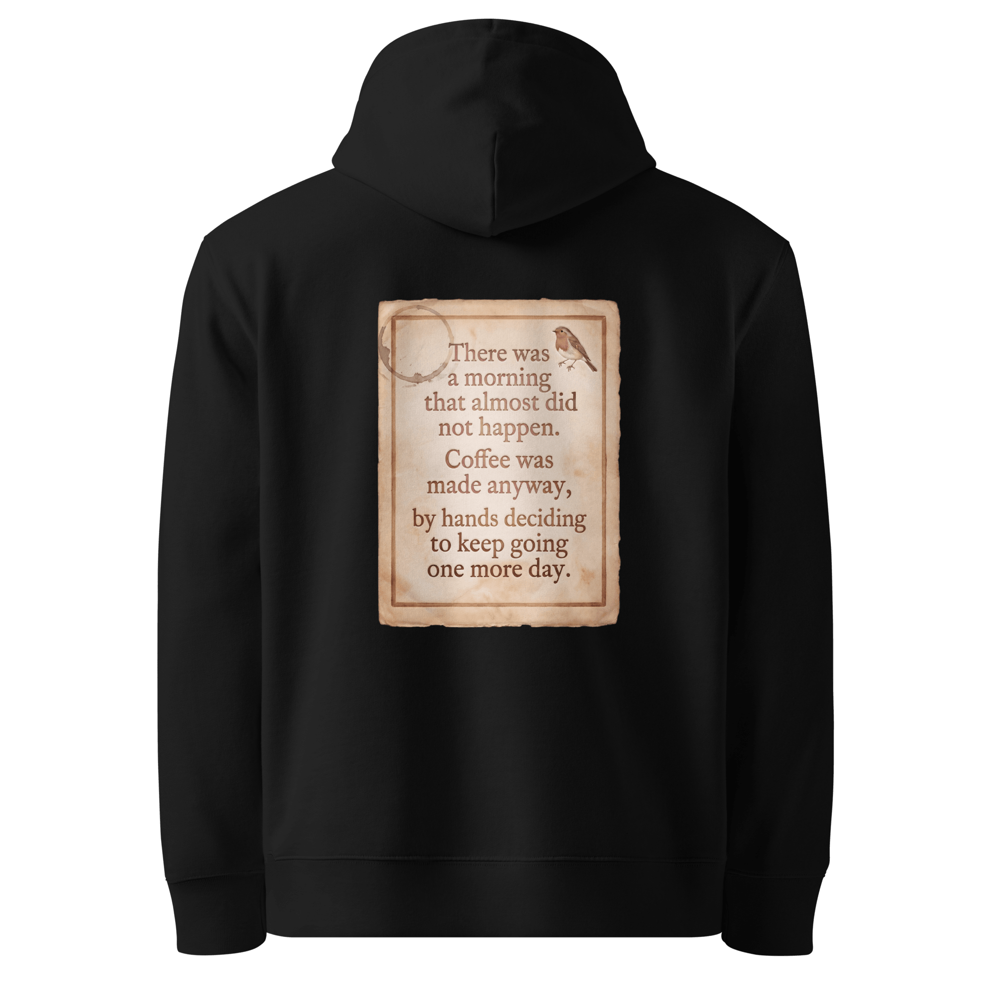 Made Anyway hoodie, black — back view of coffee-stained paper slogan plate with robin, reading "There was a morning that almost did not happen. Coffee was made anyway, by hands deciding to keep going one more day." — Ricki Robin