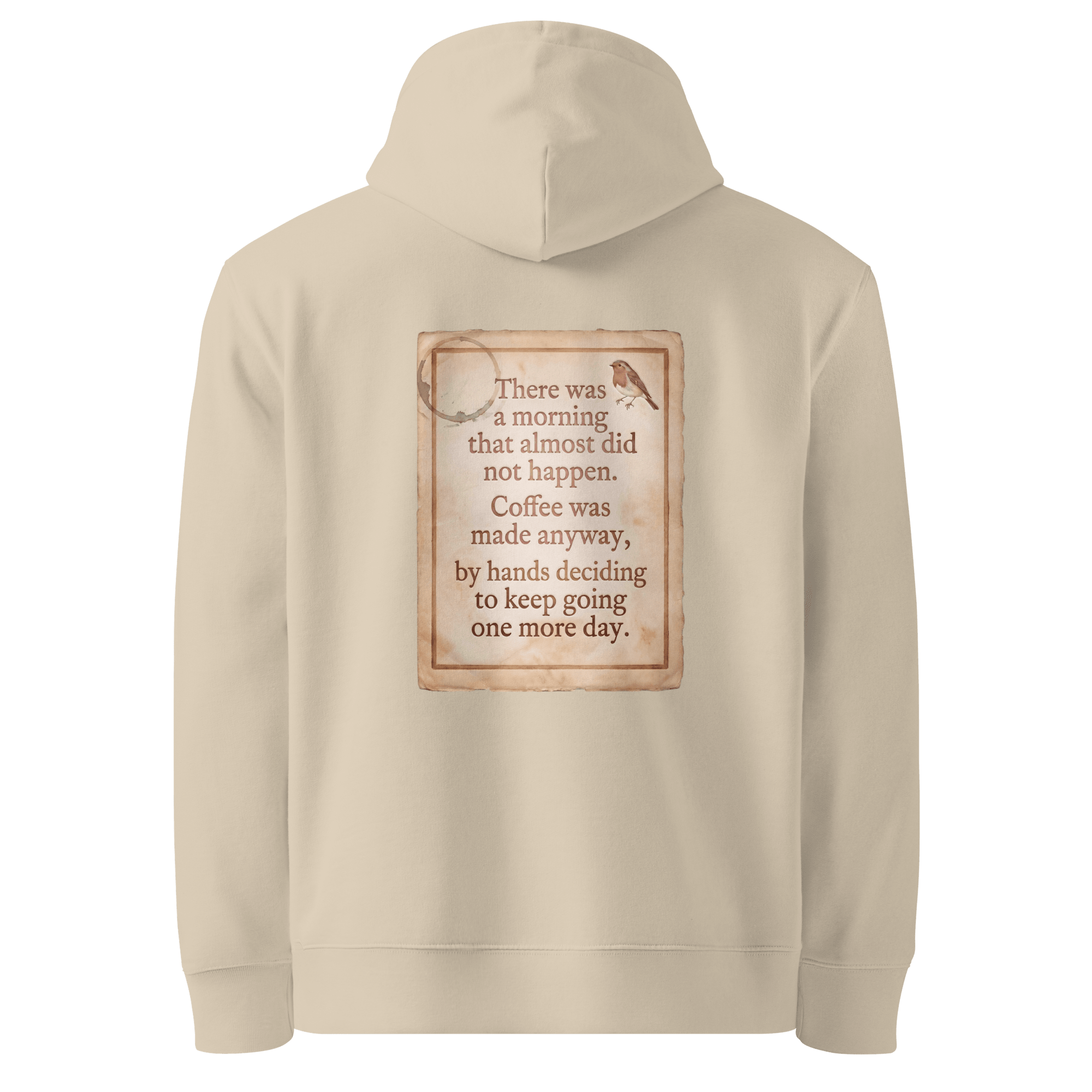 Made Anyway hoodie, Desert Dust — back view of coffee-stained paper slogan plate with robin, reading "There was a morning that almost did not happen. Coffee was made anyway, by hands deciding to keep going one more day." — Ricki Robin