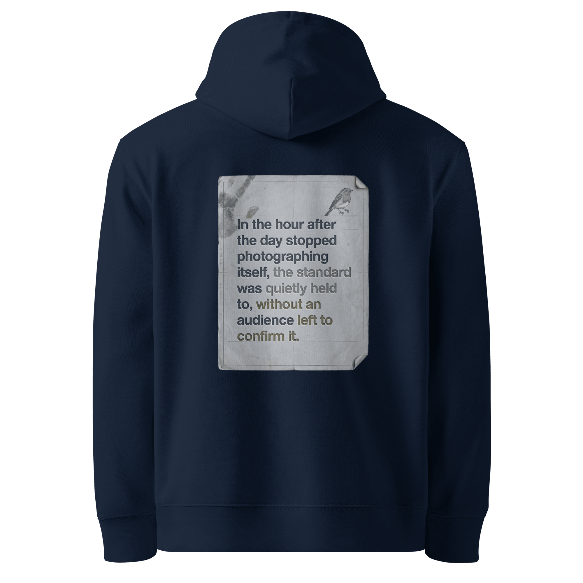Quietly Held hoodie, French Navy — back view of torn paper slogan plate with robin, reading "In the hour after the day stopped photographing itself, the standard was quietly held to, without an audience left to confirm it." — Ricki Robin